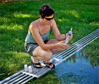 A CAP LTER student collects water samples in a stormwater retention basin